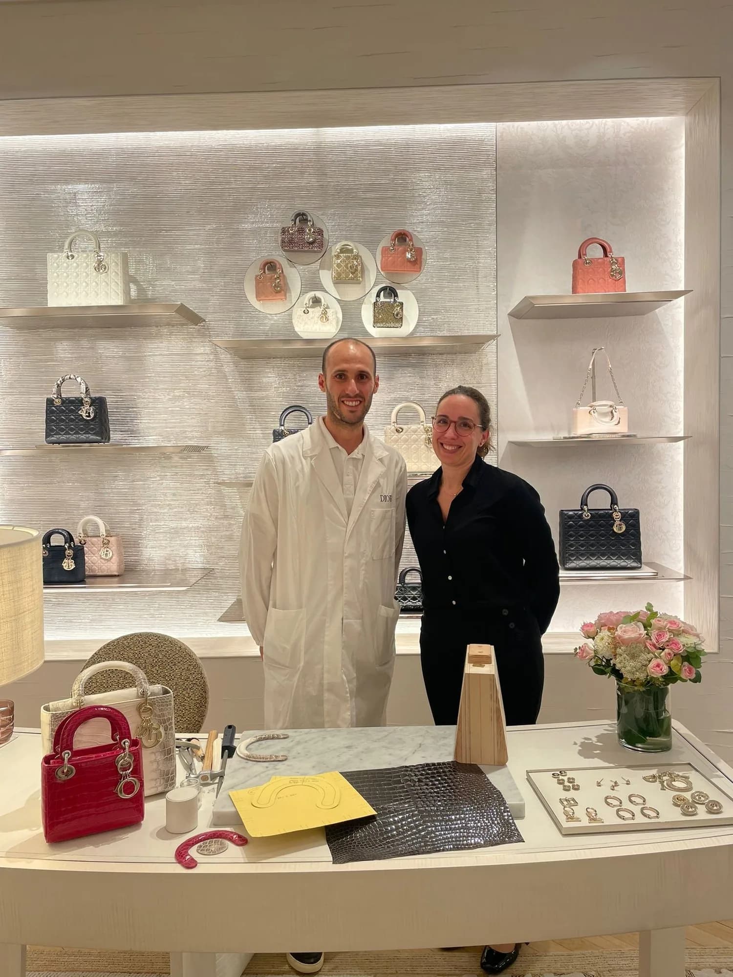 Deborah interprète un artisan maroquinier Dior devant des clients internationaux en boutique